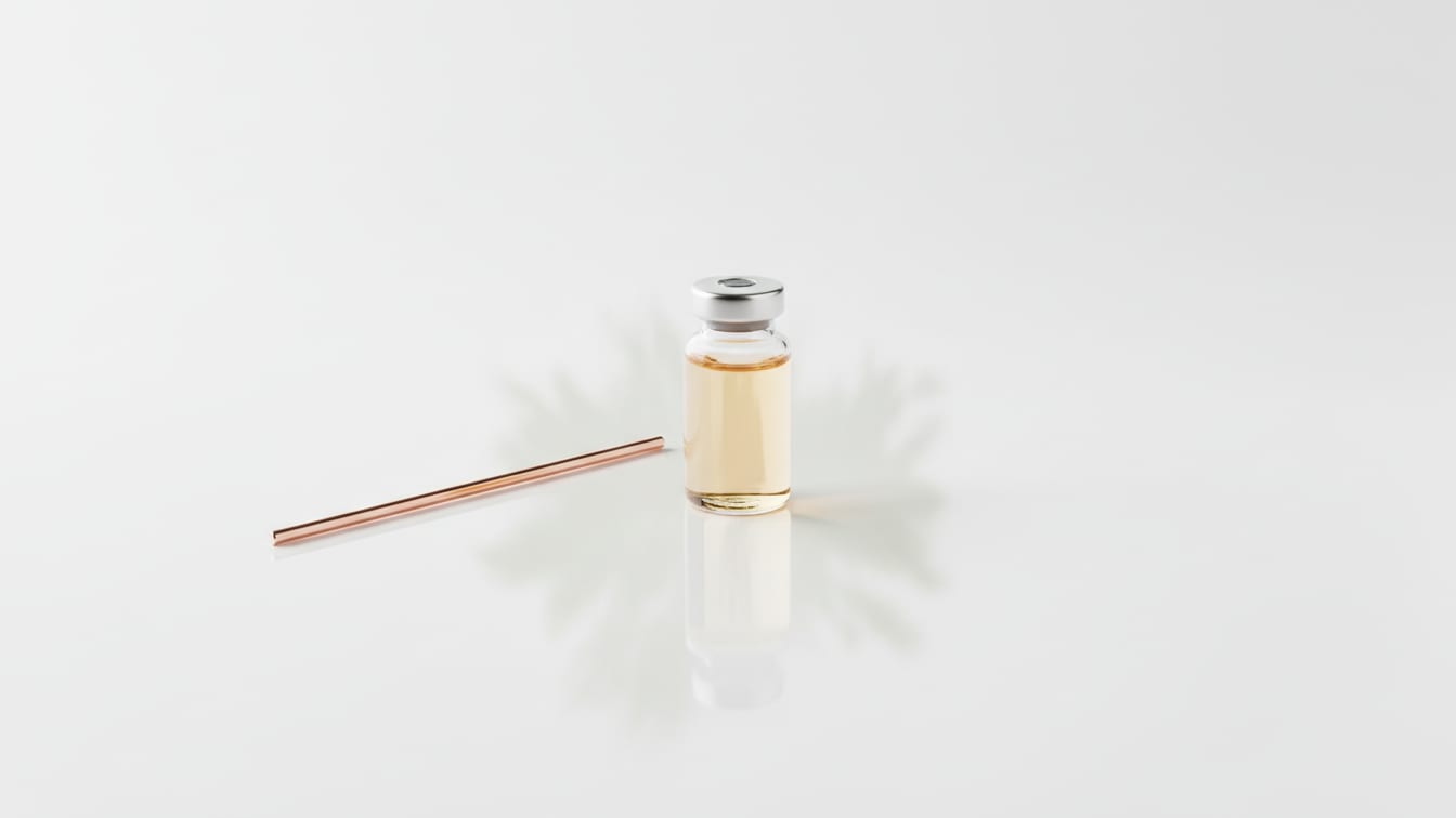Illustration: A clear glass vial with pale amber liquid, a copper stirring rod, and subtle green reflections.