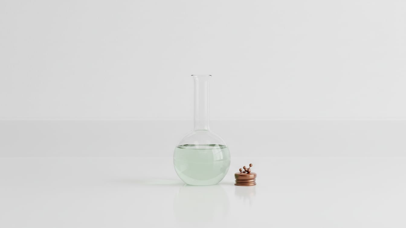 Illustration: A clear glass volumetric flask with pale green liquid, and a small copper cap on a white lab bench.